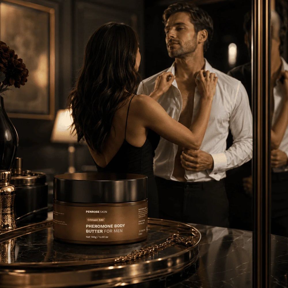 Penrose Skin Crimson 540 pheromone body butter on a gold tray as a couple gets ready in a dark, warmly lit dressing room